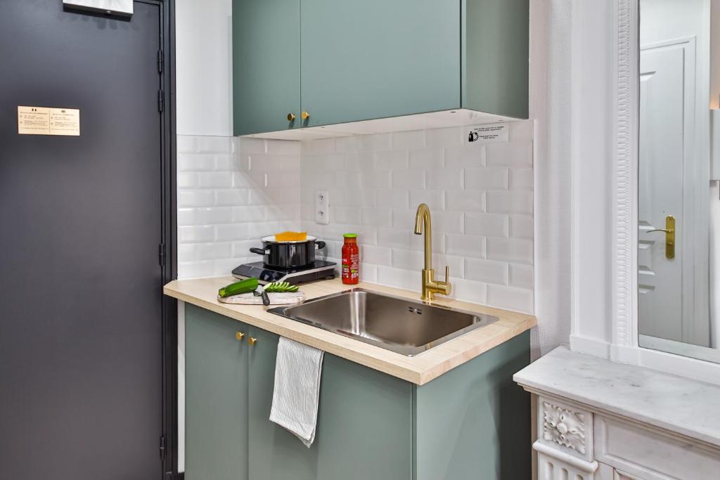 a kitchen with a sink and a microwave at Apartments WS Tour Eiffel - Laos in Paris