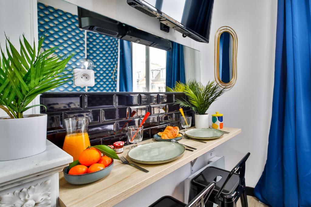 a kitchen with a table with plates of fruit on it at Apartments WS Tour Eiffel - Laos in Paris