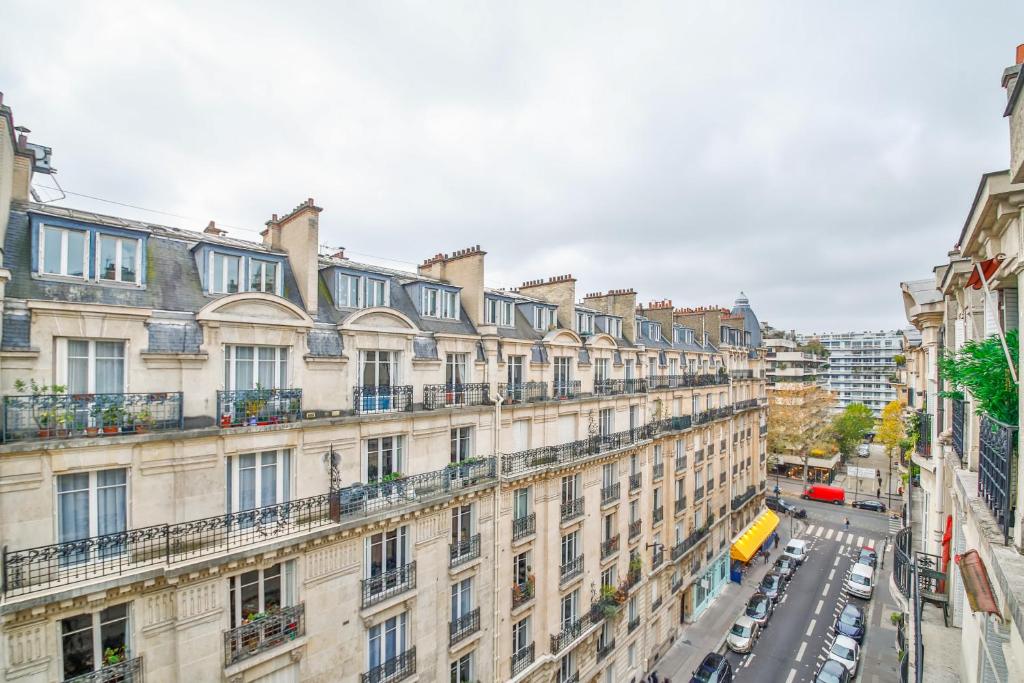an apartment building with cars parked on a street at Apartments WS Tour Eiffel - Laos in Paris