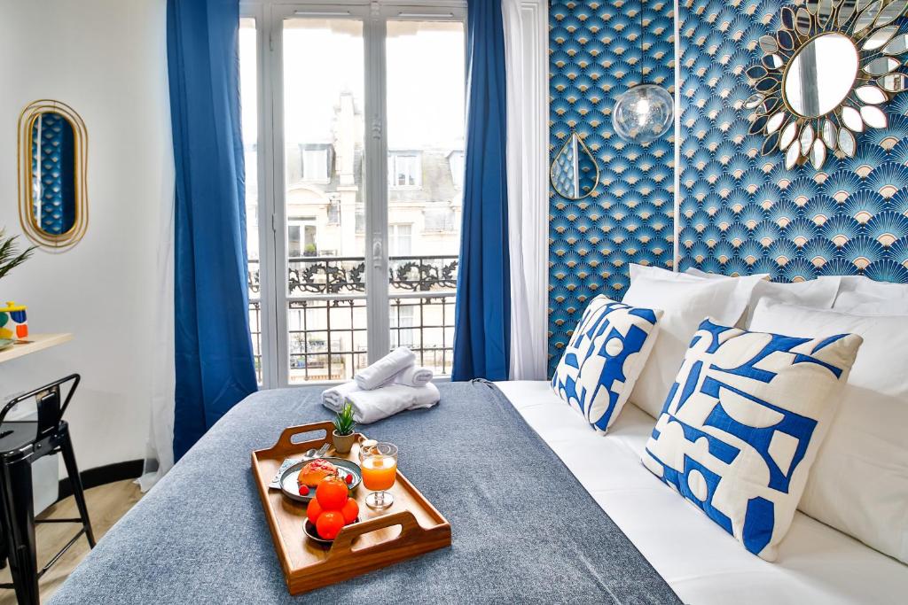 a room with a bed with a tray of food on it at Apartments WS Tour Eiffel - Laos in Paris
