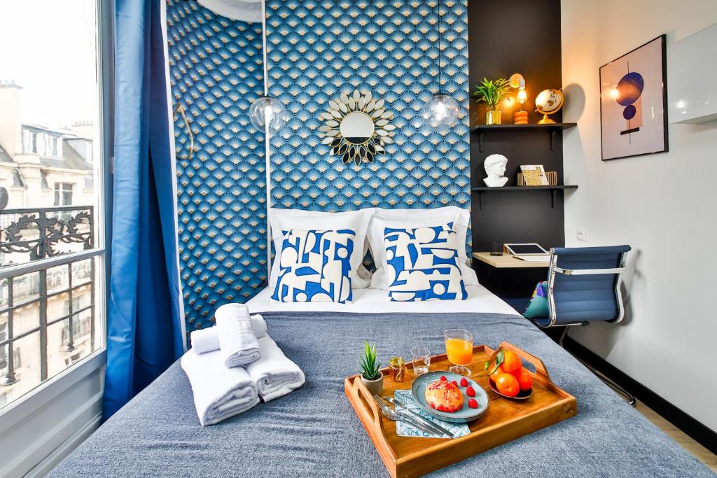 a bedroom with a bed with a tray of food on it at Apartments WS Tour Eiffel - Laos in Paris