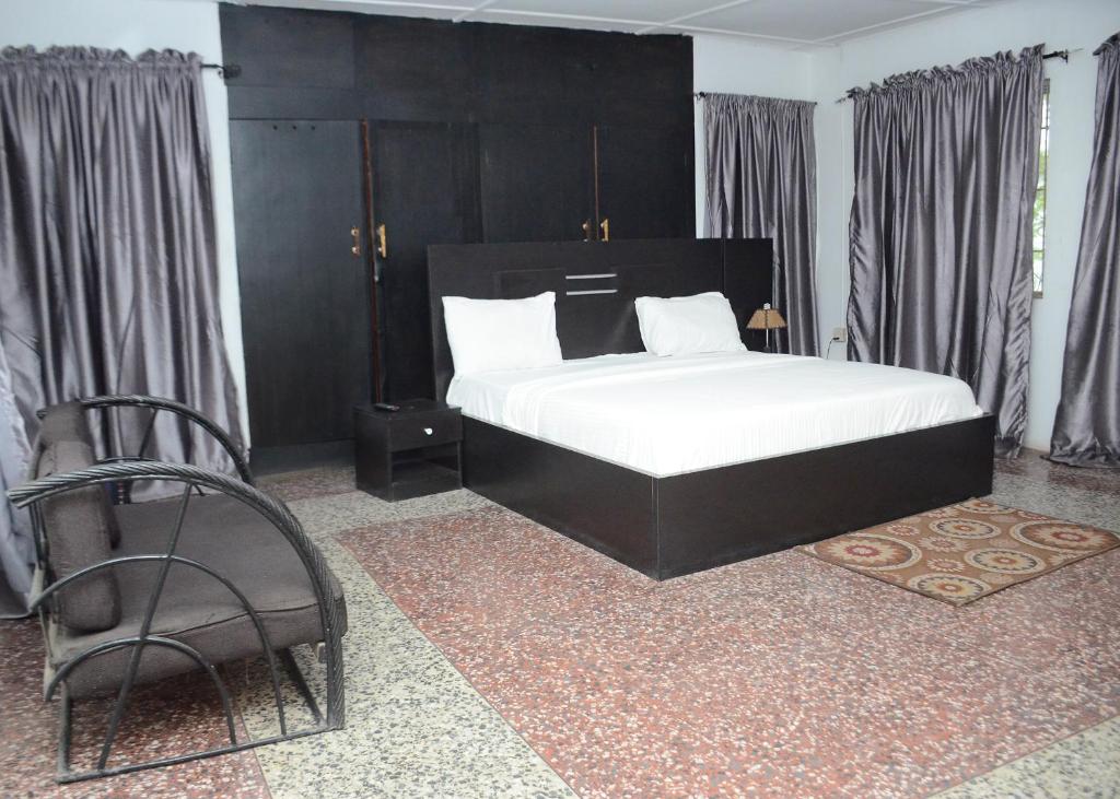 - une chambre avec un grand lit et une chaise dans l'établissement House 5 Ibara Housing, Abeokuta, à Abeokuta