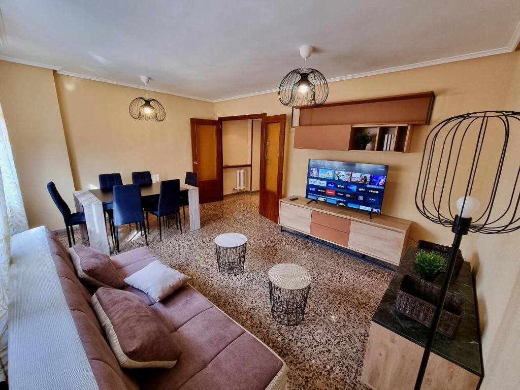 ein Wohnzimmer mit einem Sofa und einem Esszimmer in der Unterkunft Apartamento Montse Zaragoza in Saragossa