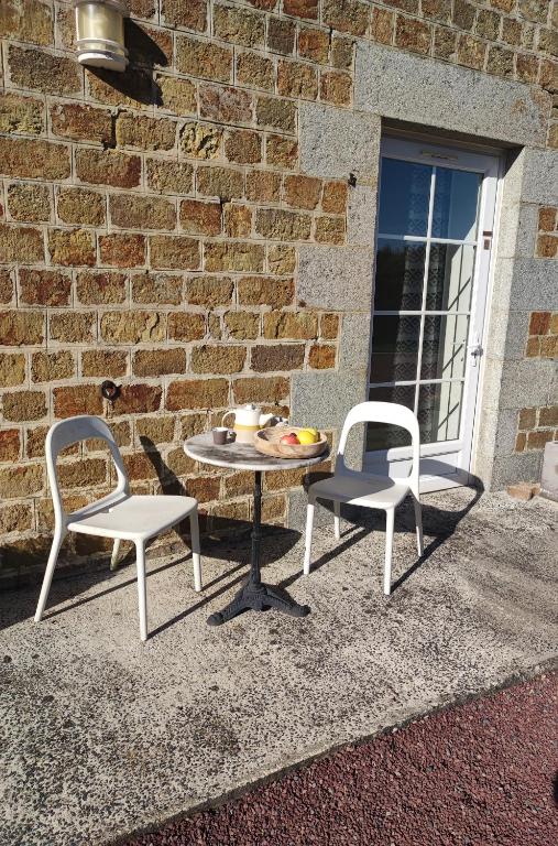 two chairs and a table and a table and two chairs at La Minoterie in Tessy-sur-Vire