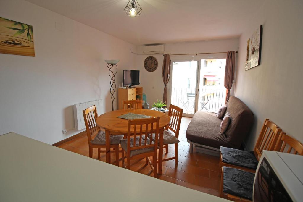 ein Wohnzimmer mit einem Tisch, Stühlen und einem Sofa in der Unterkunft Apart-rent Apartamento Gran reserva 0068 in Empuriabrava