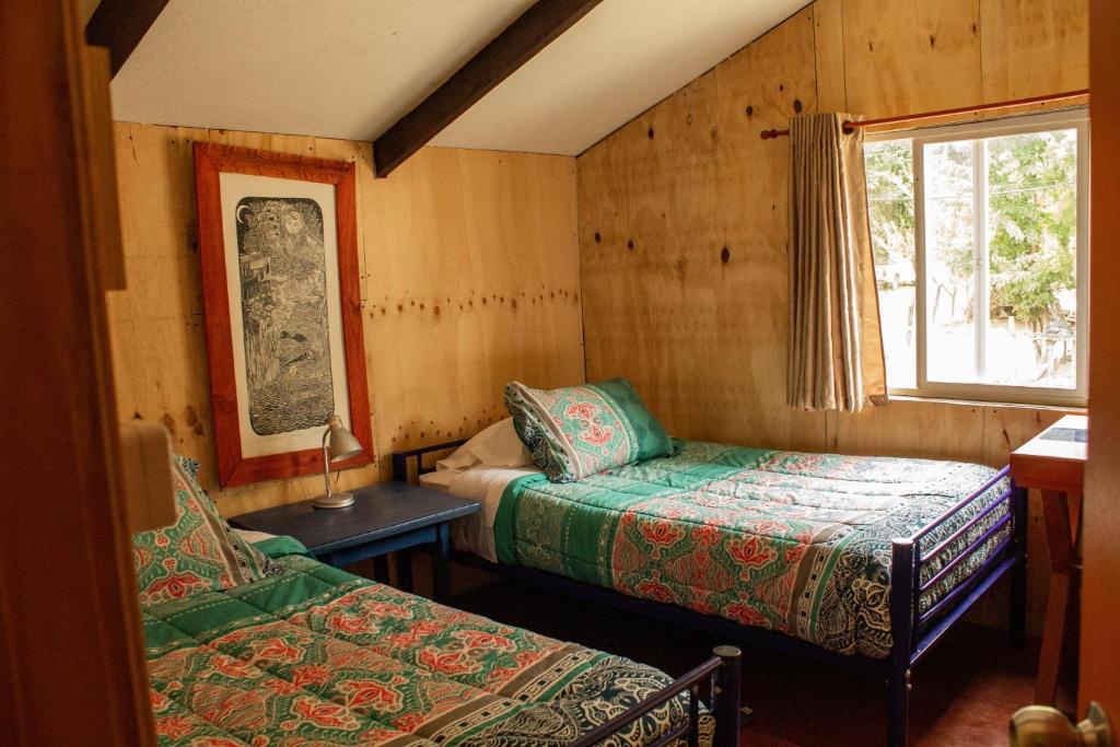 a small room with two beds and a window at Azurita in Futaleufú