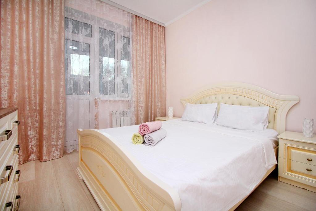 um quarto com uma cama branca com duas toalhas em ЖК Верный, 3-комнатная квартира, рядом с верхней Мегой, вдоль речки em Almaty