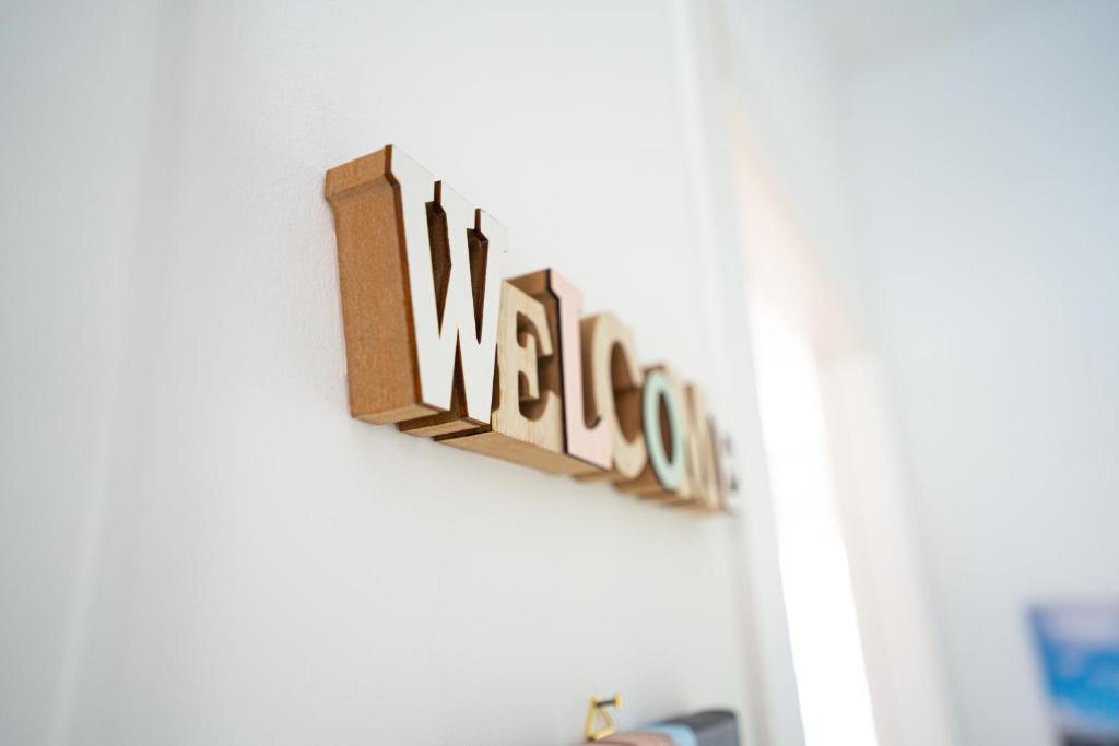 a sign that says welcome hanging on a wall at MICKY HOUSE in Sanremo