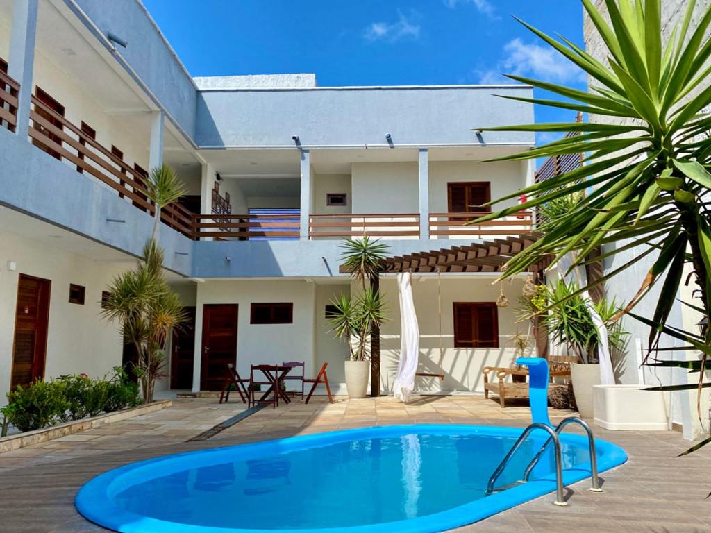 uma villa com piscina em frente a uma casa em Pousada Vila Tutóia em Tutóia