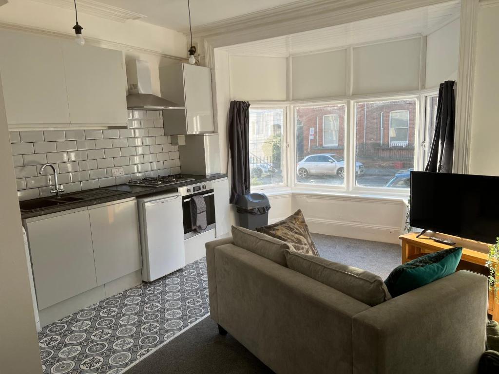 a living room with a couch and a kitchen at Flat in Leamington Spa town centre in Leamington Spa