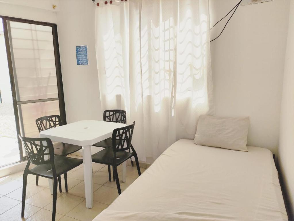 a small room with a bed and a table and chairs at Apartamentos Villa Leonor in Coveñas