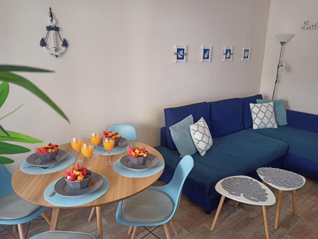 een woonkamer met een blauwe bank en een tafel en stoelen bij Nice Place Santa Pola in Santa Pola