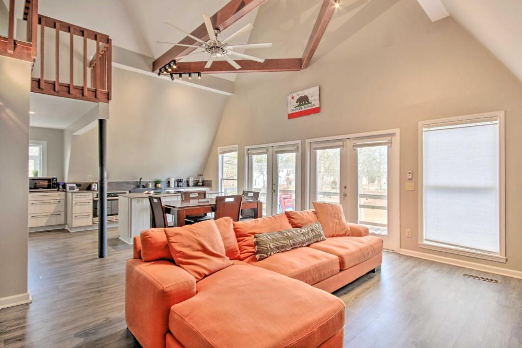 a living room with an orange couch and a kitchen at Waterfront Chapin Home with Private Dock! in Lake Murray Shores