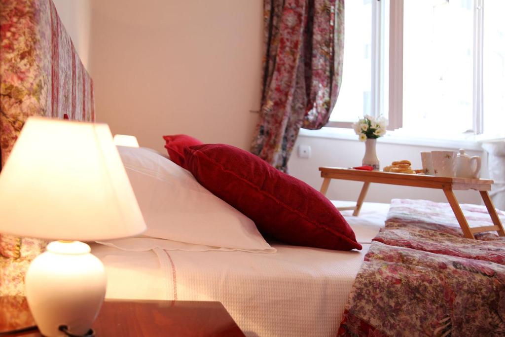 a bedroom with a bed with red pillows and a lamp at Apartment Alloga in Belgrade