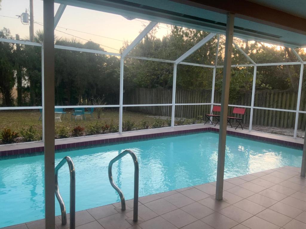 einen Pool mit einer Pergola neben einem Haus in der Unterkunft Casa Limon with HEATED POOL in Sarasota
