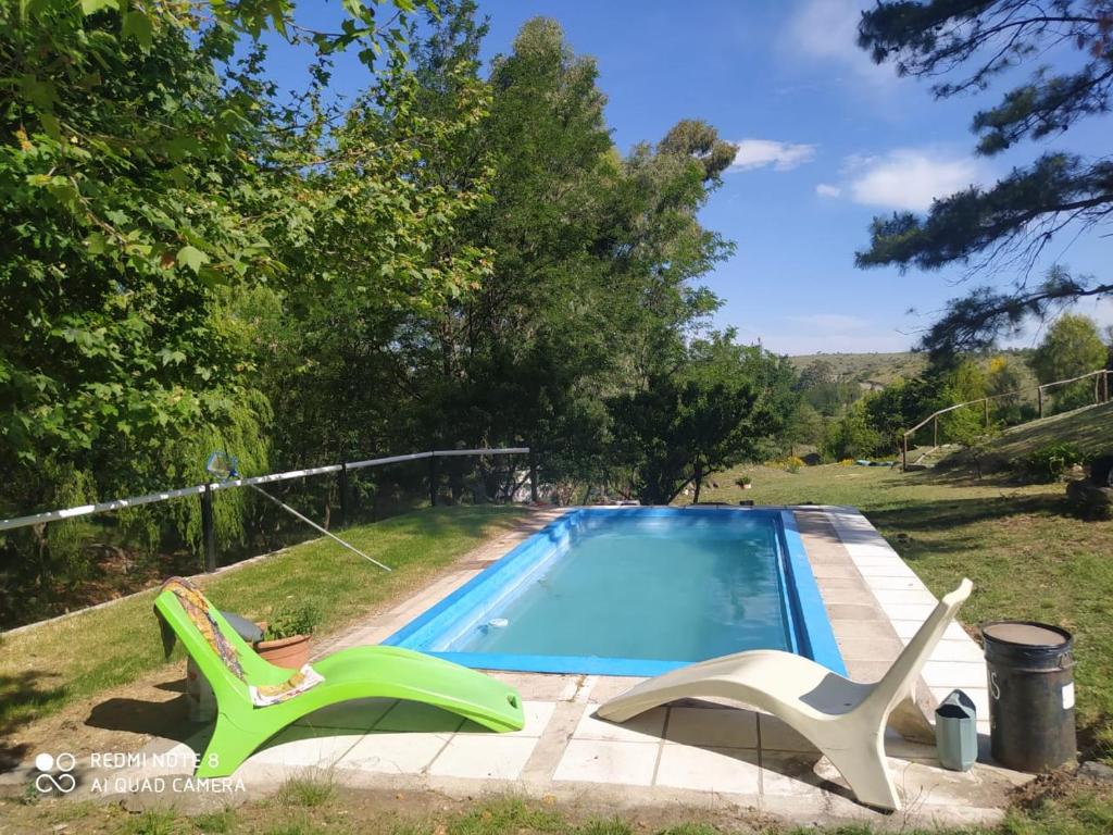 una piscina con 2 sillas de jardín junto a ella en Aike Cabañas de Montaña en San Clemente