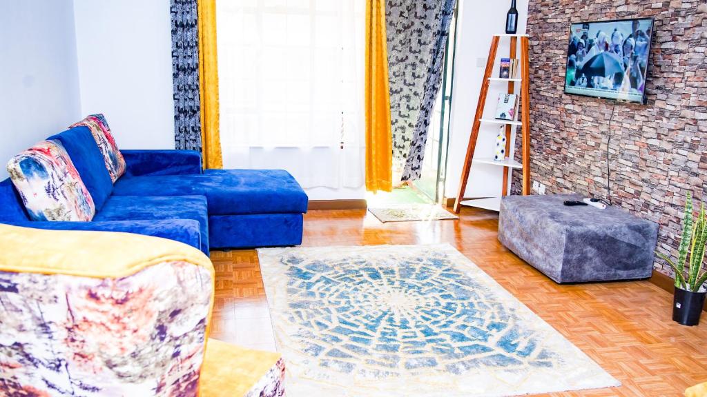 a living room with a blue couch and a rug at Primal apartment at Embakasi, Nairobi, Kenya. in Nairobi