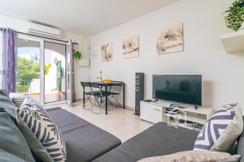 uma sala de estar com um sofá e uma televisão de ecrã plano em Apartamento SARAY em Son Carrio