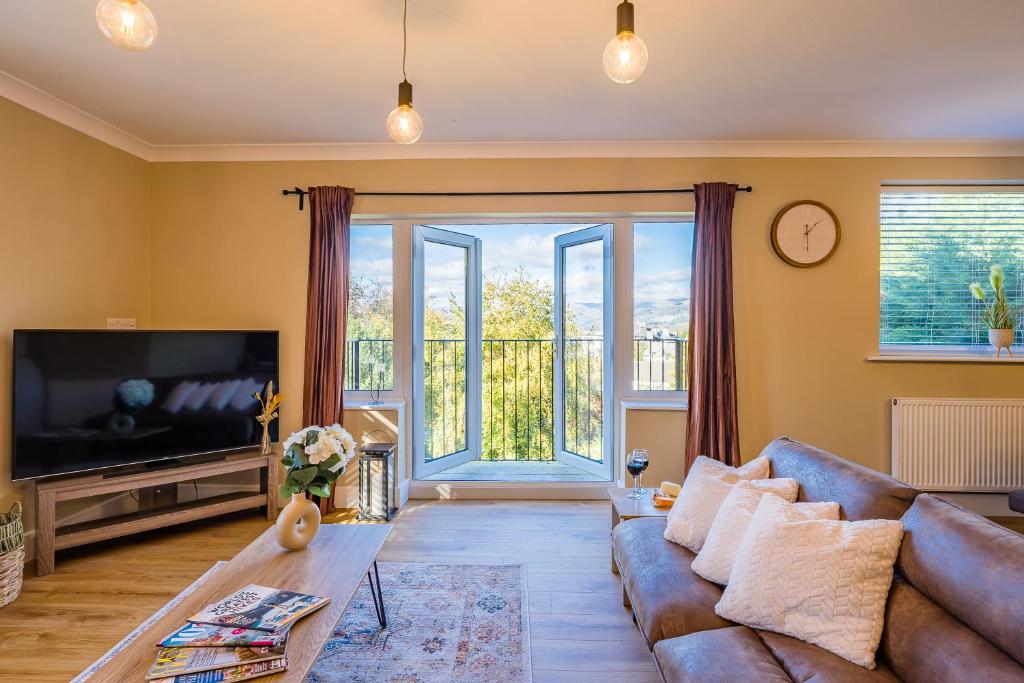 a living room with a couch and a large window at Lake View Retreat, Pet Friendly, Free Parking, Lake View, Golf nearby in Bowness-on-Windermere