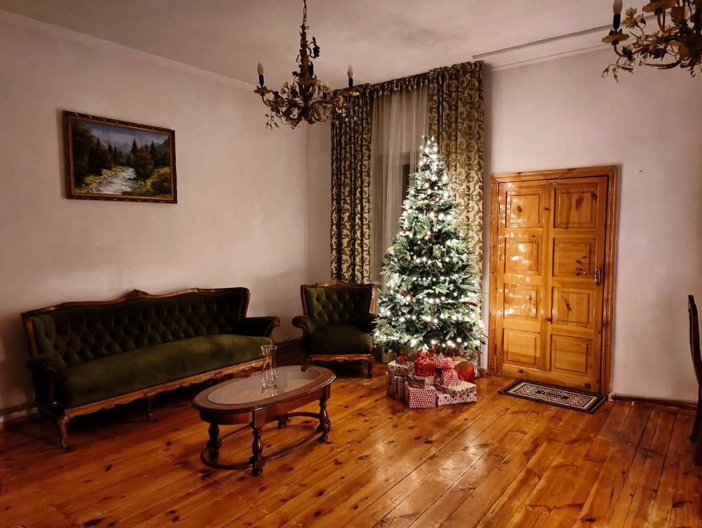 ein Wohnzimmer mit einem Weihnachtsbaum und einer Couch in der Unterkunft Sweet Vibe Home in Almaty