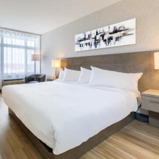 ein großes weißes Bett in einem Hotelzimmer in der Unterkunft Repotel Levis in Lévis