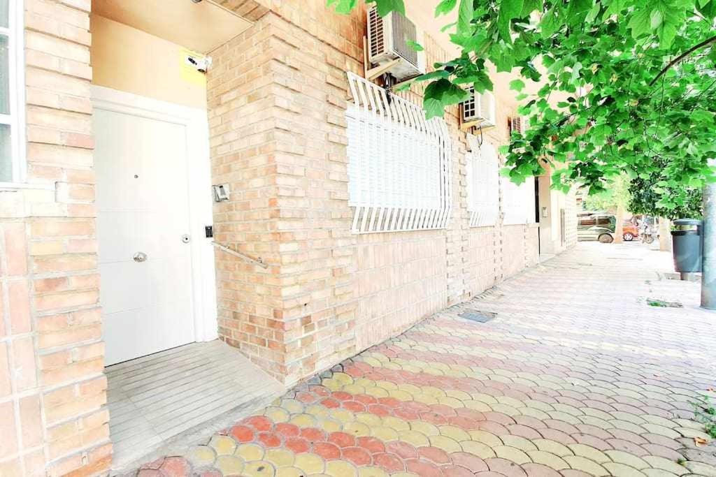 a sidewalk with a brick wall and a white door at Vivienda Turistica Valencia 1 - Grandes Grupos in Valencia