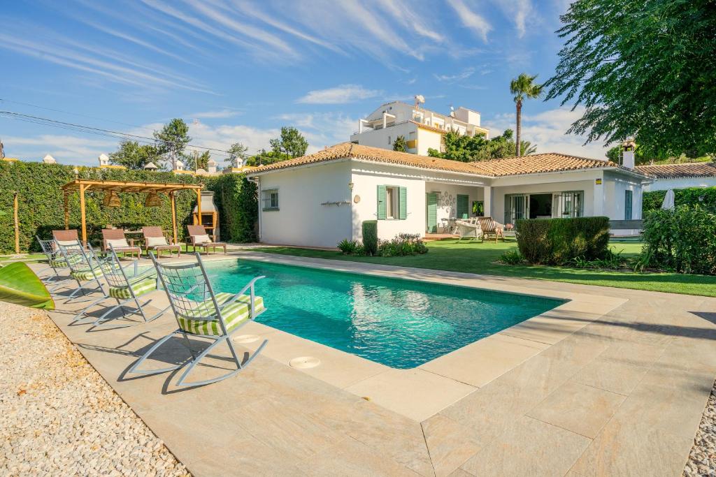 a swimming pool with chairs and a house at Villa en Marbella Artola&Friends in Marbella