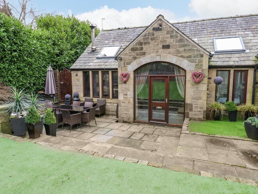 a house with a patio with a table and chairs at Dale Cottage in Oldham
