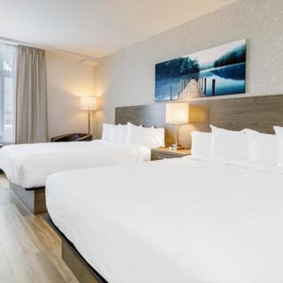 ein Hotelzimmer mit 2 Betten und einem Fenster in der Unterkunft Repotel Levis in Lévis