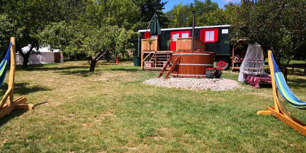 einen Spielplatz mit zwei Schaukeln und einem Spielhaus in der Unterkunft Naphegy Kuckó in Écs