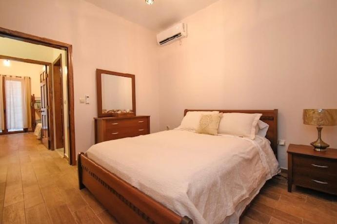 a bedroom with a large bed and a mirror at Aktea coastal village home in Kalymnos