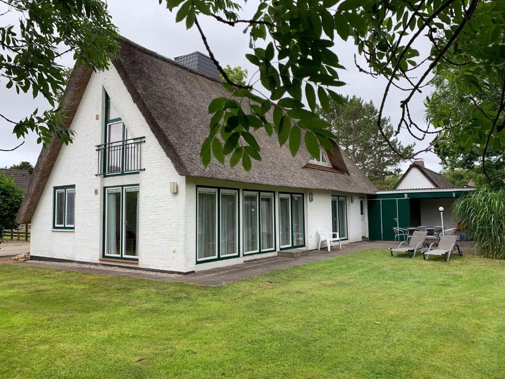 uma casa branca com janelas e um quintal em Haus-Friesenstrasse-Whg-17 em Sankt Peter-Ording