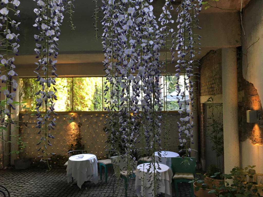 a room with tables and purple flowers hanging from the ceiling at Kindl 's Low Budget in Vienna