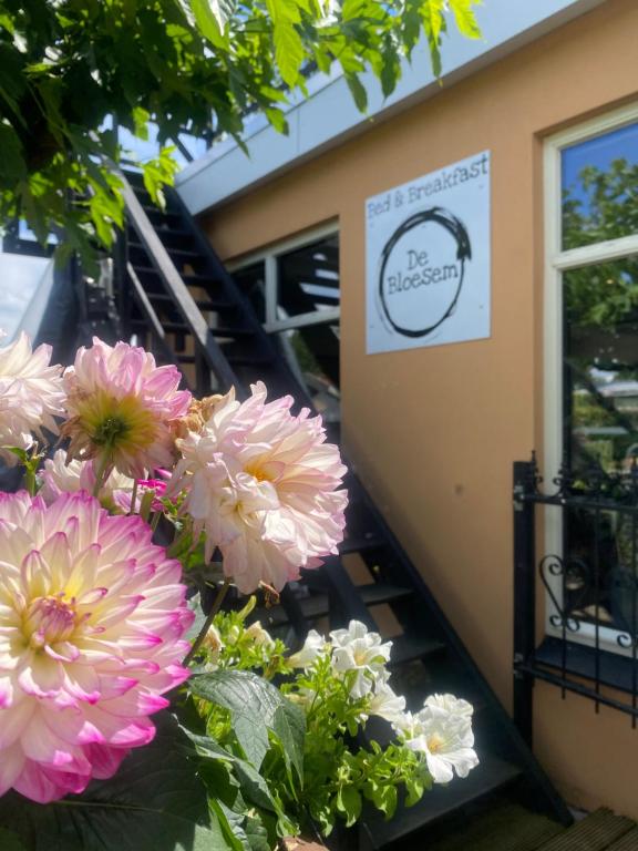 un ramo de flores rosas delante de una escalera en De Bloesem, en Cothen