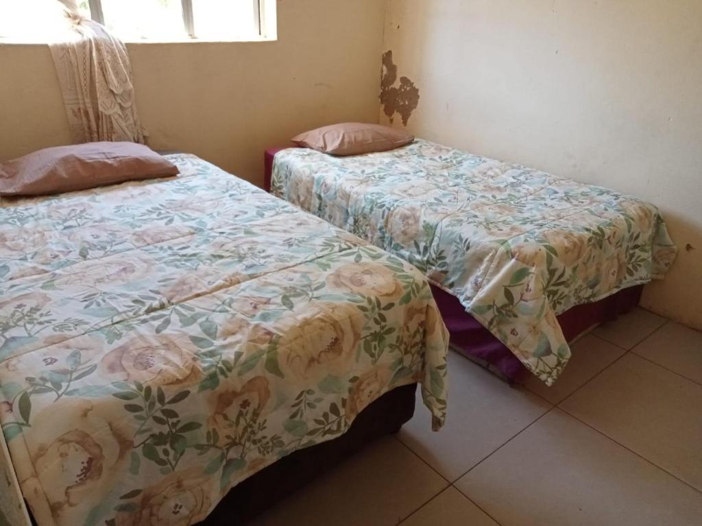 two beds sitting next to each other in a room at Lamont Lodge in Durban