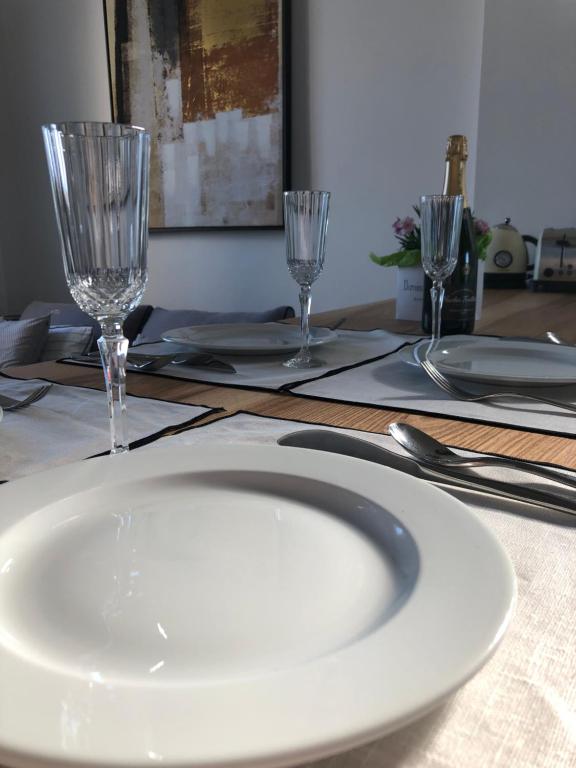 a table with a white plate and two wine glasses at Belle vue sur mer, très près du port de Sanary in Sanary-sur-Mer