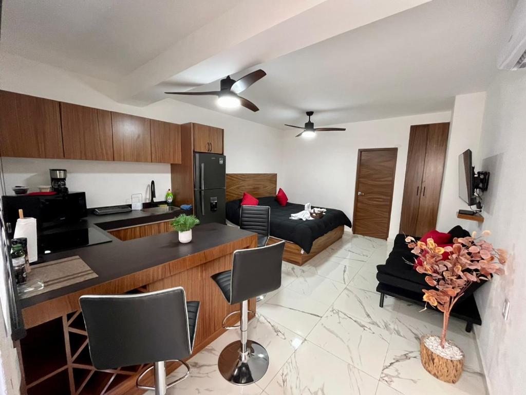 a living room and kitchen with a couch and a table at AHAU Playa in Playa del Carmen