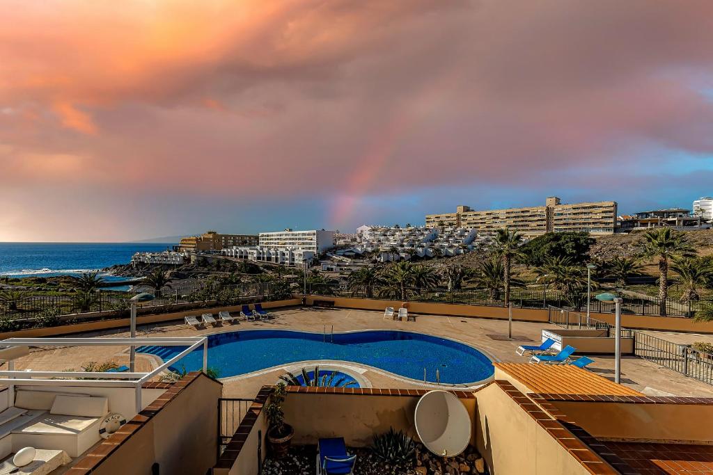un arco iris en el cielo sobre una piscina y el océano en Casa del Mar, en Callao Salvaje