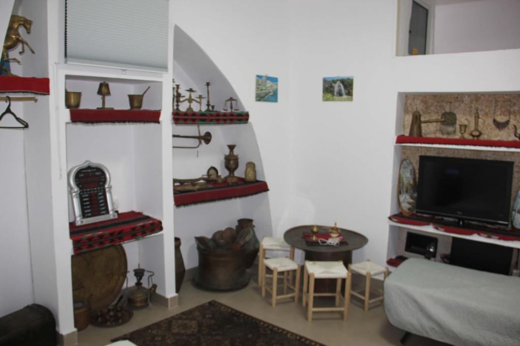 a living room with a couch and a tv at Shamokh House in Acre