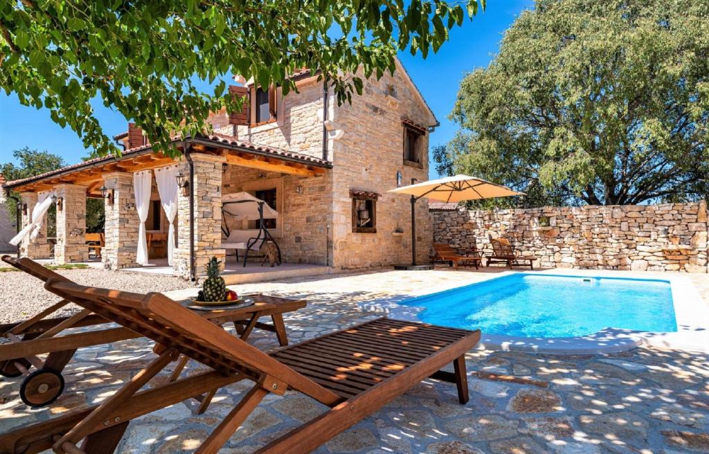 una villa con piscina di fronte a una casa di MY DALMATIA - Authentic villa Malou with private swimming pool a Stankovci