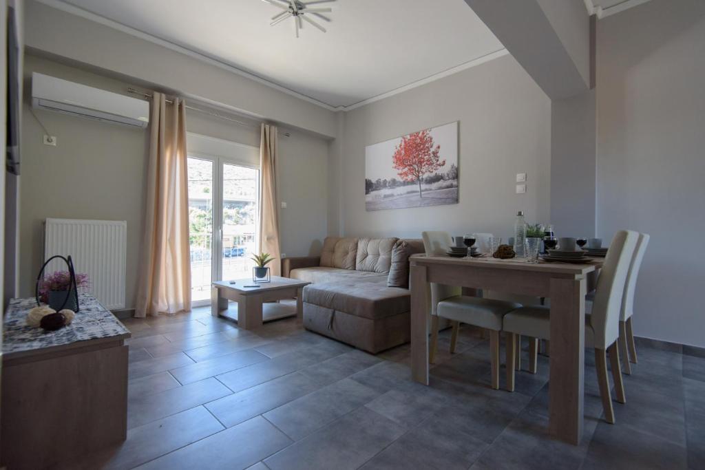 ein Wohnzimmer mit einem Tisch und einem Sofa in der Unterkunft Andriana' s apartment Agia Paraskevi in Athen