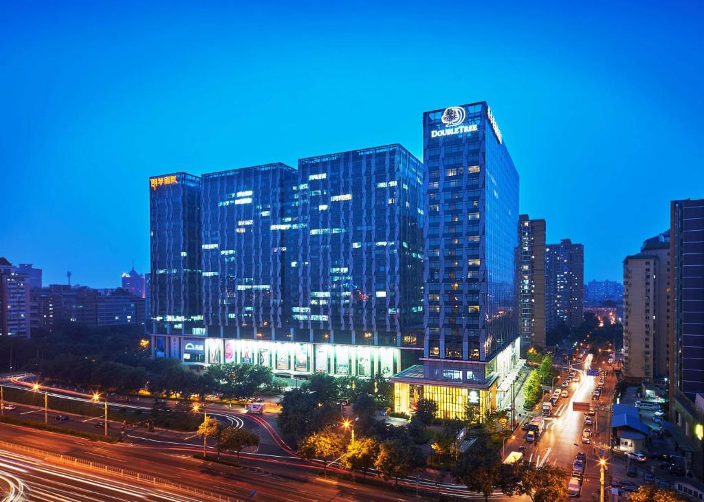 um horizonte da cidade à noite com um edifício alto em DoubleTree by Hilton Beijing em Pequim