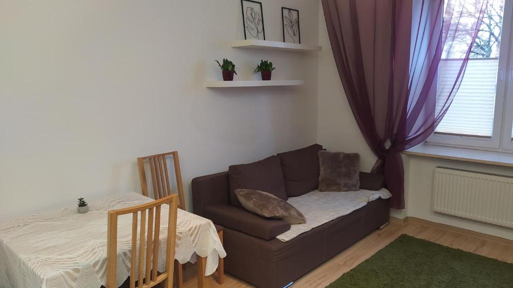 Apartament Szczęśliwicka في وارسو: غرفة معيشة مع أريكة وطاولة
