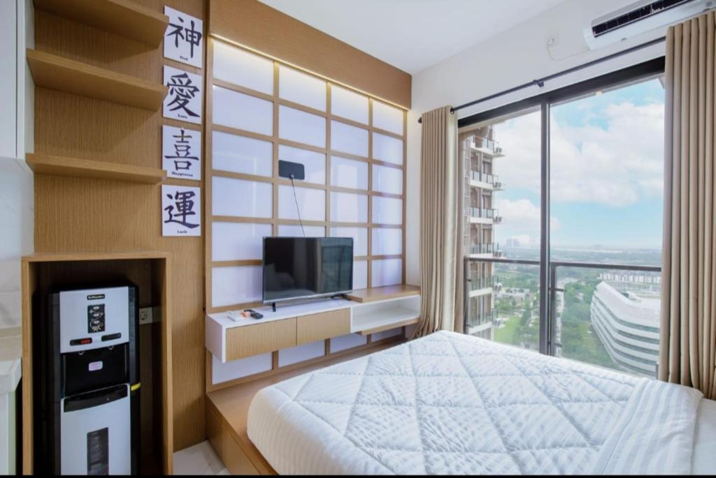 um quarto com uma cama, uma televisão e uma janela em Rika Apartement at sky house bsd em Ciater-hilir