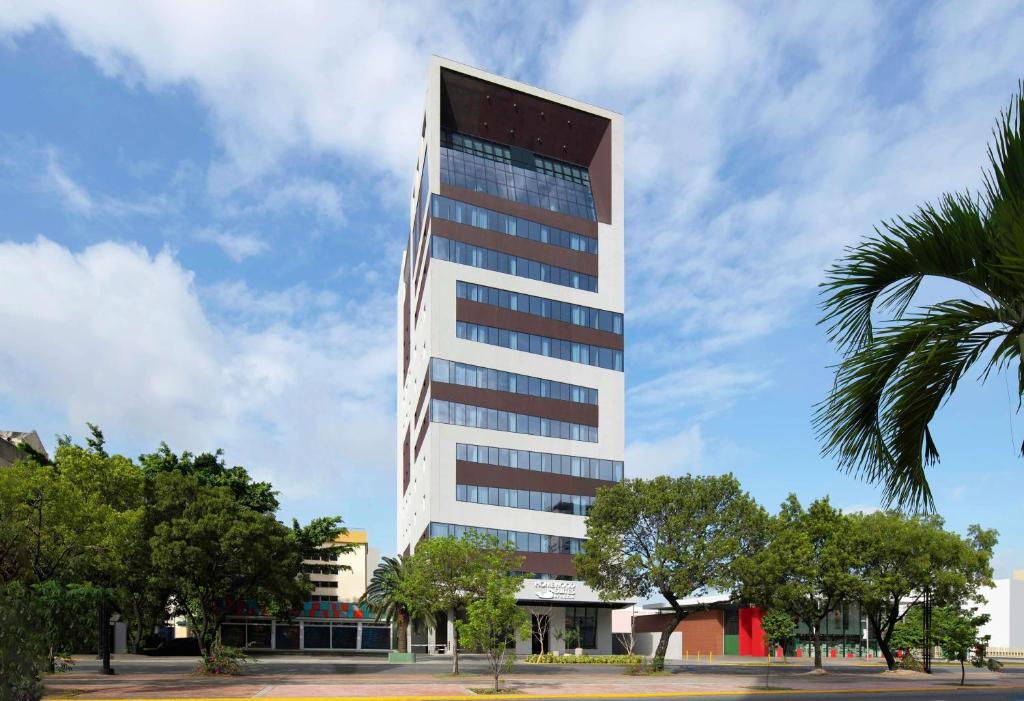 サントドミンゴにあるHomewood Suites By Hilton Santo Domingoのヤシの木が目の前にそびえる高い建物