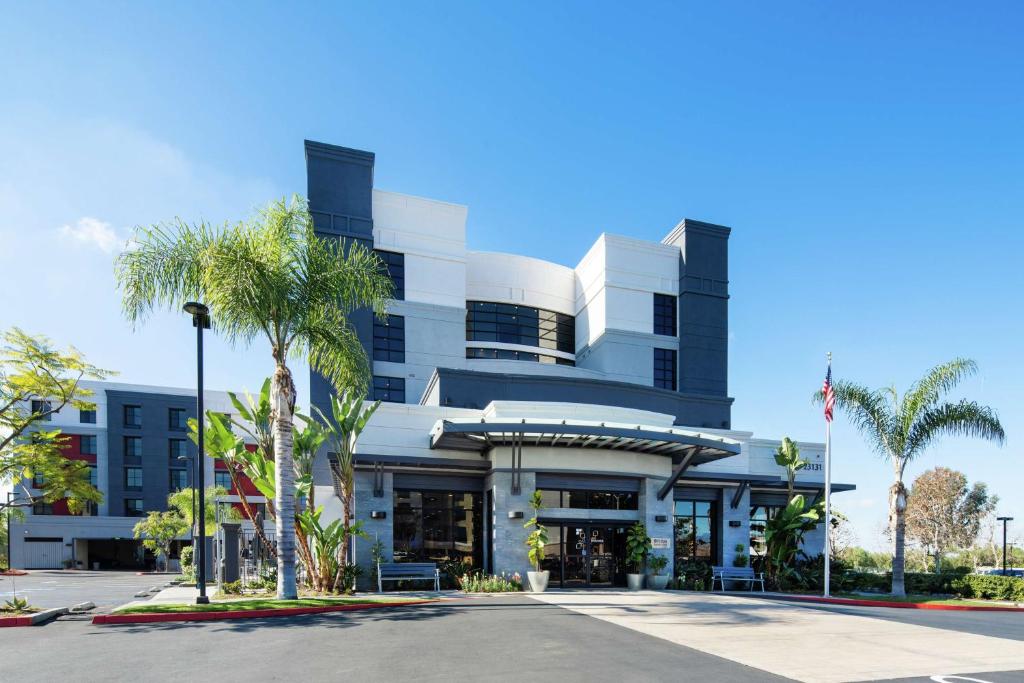 a building with palm trees in front of it at Hilton Garden Inn Irvine Spectrum Lake Forest in Lake Forest