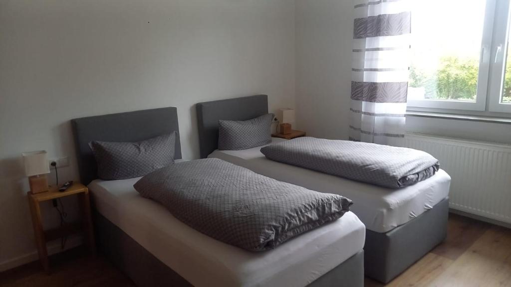 2 Einzelbetten in einem Zimmer mit Fenster in der Unterkunft Katjas Ferienwohnungen in Giebelstadt