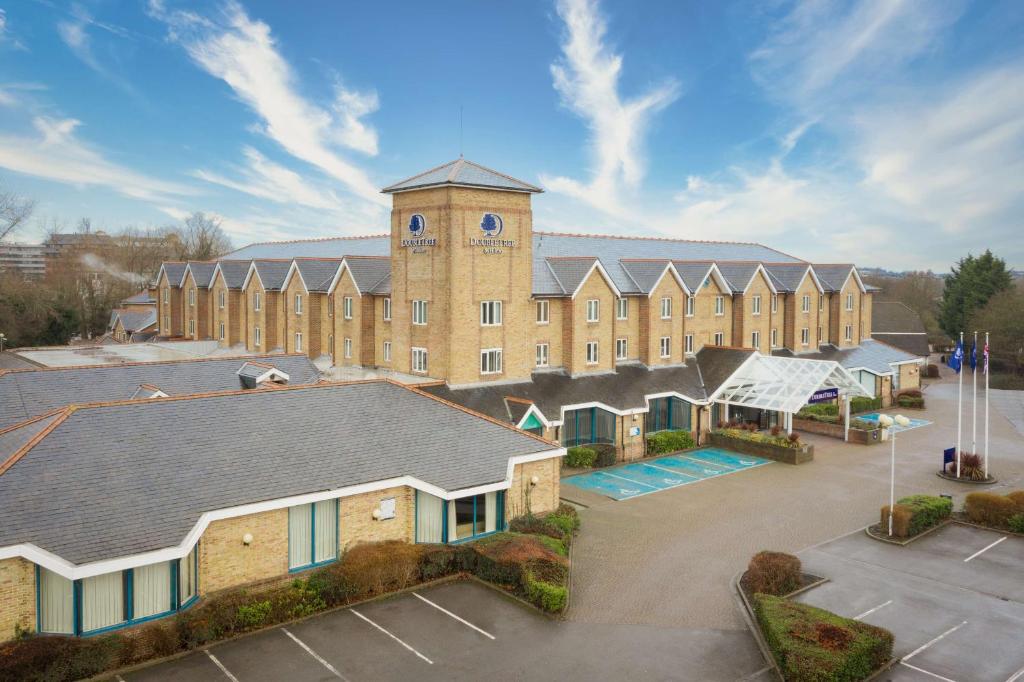 un grande edificio in mattoni con torre dell'orologio di DoubleTree by Hilton London Elstree a Borehamwood