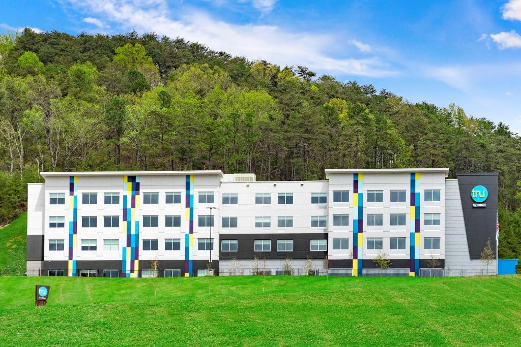 a white building with a hill in the background at Tru By Hilton Cartersville, Ga in Cartersville