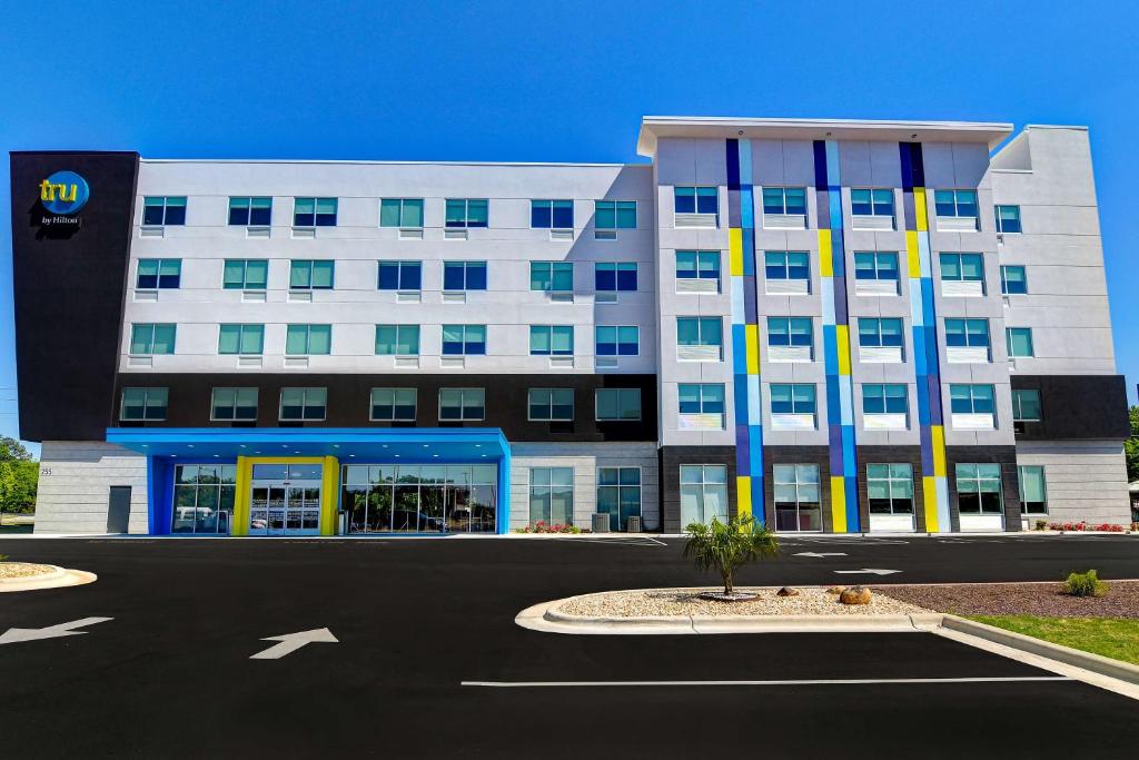 een groot wit gebouw met gele en blauwe zuilen bij Tru By Hilton Rocky Mount, Nc in Rocky Mount